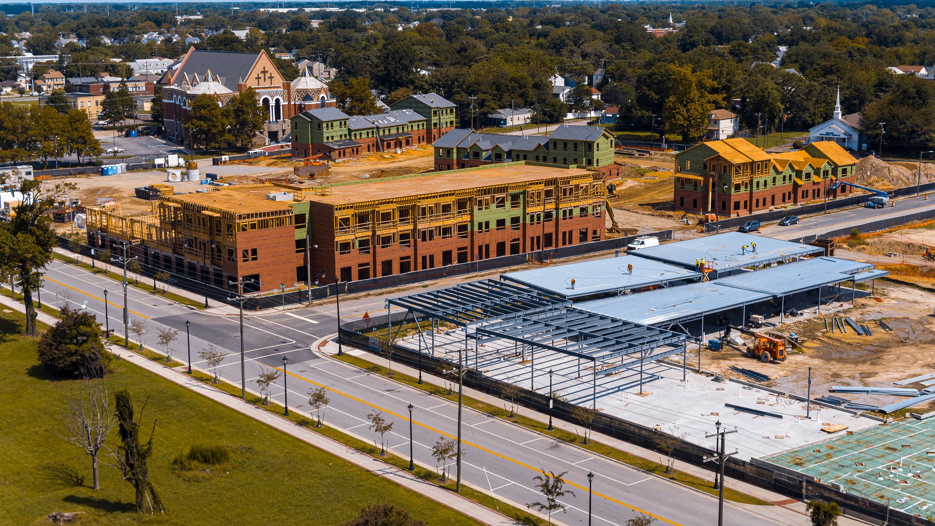 Construction site in small neighborhood. Colorful unfinished multi story building rise above Marshall community in Newport News, Virginia. Aerial view